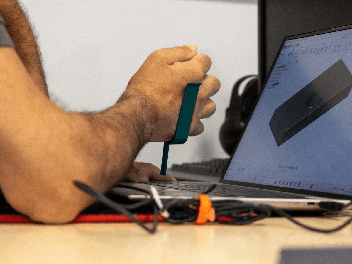 Persona utilizando una ayuda funcional personalizada fabricada con impresión 3D para teclera en el ordenador más fácilmente.